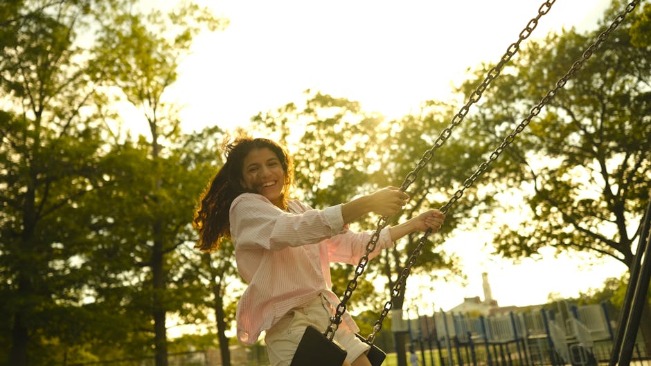 Smiling woman enjoying a moment of stretching in nature during sunrise.